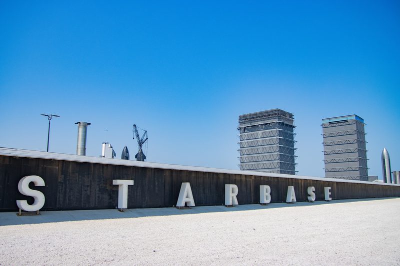 The Starbase sign and launch towers at SpaceX's Starbase site in South Texas
